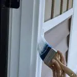 Freshly painted white door trim receiving a smooth finish coat from an angled brush in Chesterland, OH